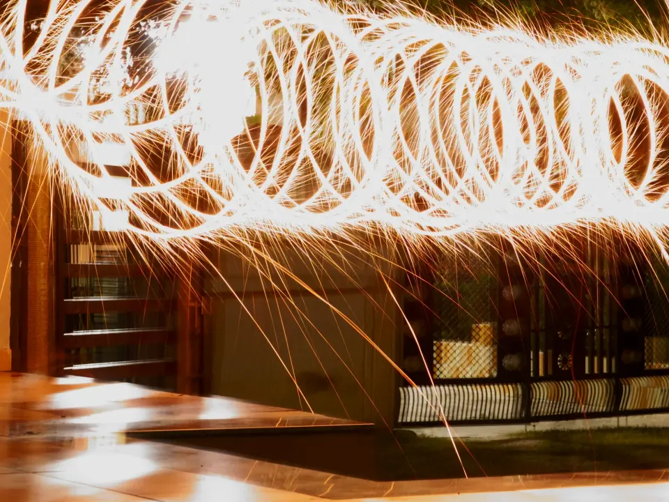 Long-exposure spirals of golden sparks over a polished floor