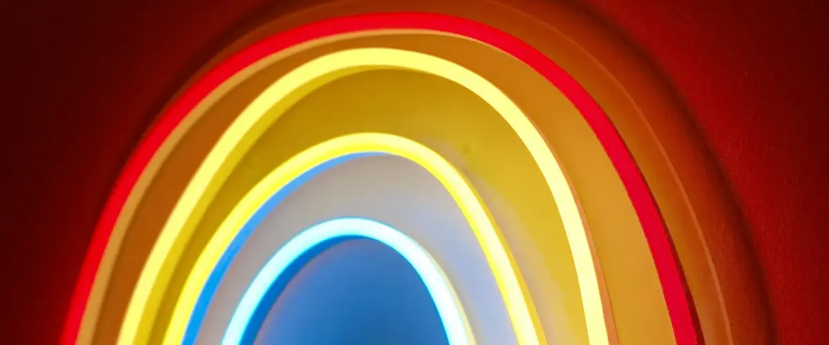 Glowing neon rainbow light on a red wall